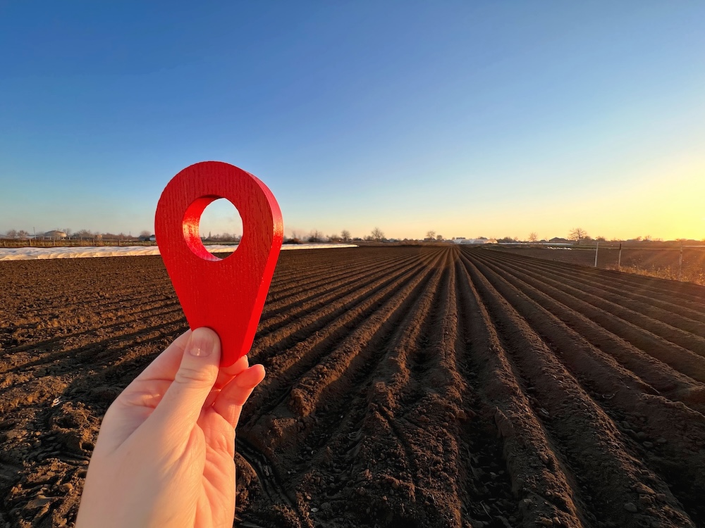ręka zr znacznikiem na działce rolniczej ręka trzymająca znacznik na tle działki