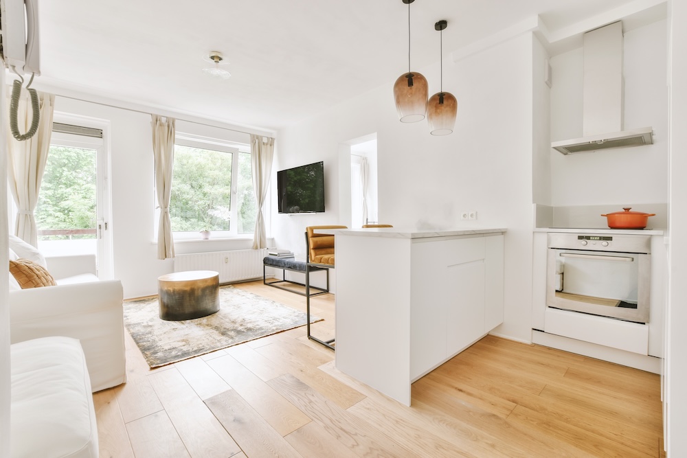 biała kuchnia z wyspą i salonem jasna kuchnia oddzielona od salonu wyspą