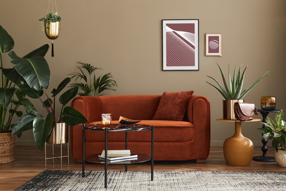 sofa w rudym kolorze i czarny stolik kawowy w salonie welurowa ruda kanapa ze stolikiem na dywanie