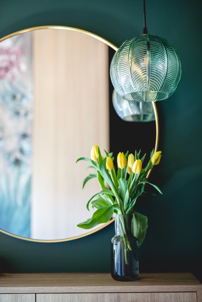lampa z turkusowym kloszem przy lustrze 